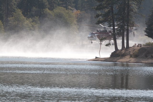 Helicopter Sprays Water on Lake to Fight Fire