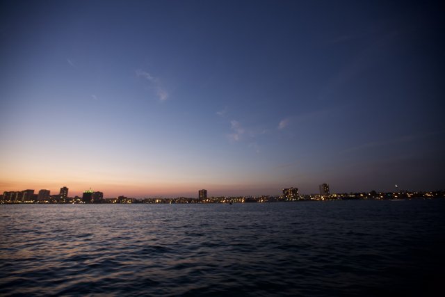 Sun sets over urban skyline from the water