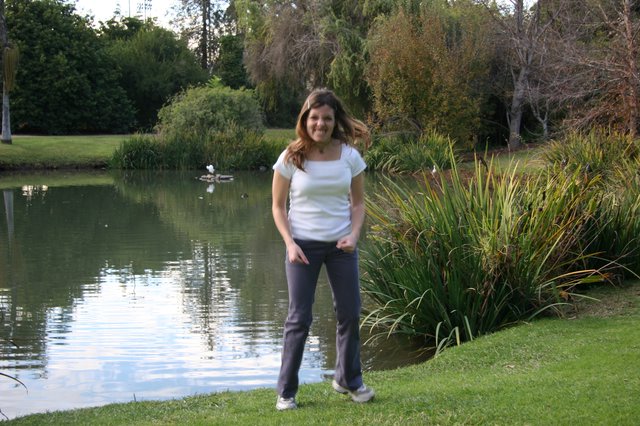 Woman Smiling by a Tranquil Park Pond