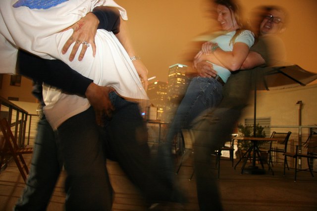 Couples Dancing on Rooftop Under City Lights
