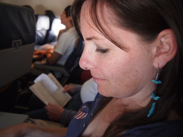 Quiet Reflection: Woman Reading Aboard a Flight
