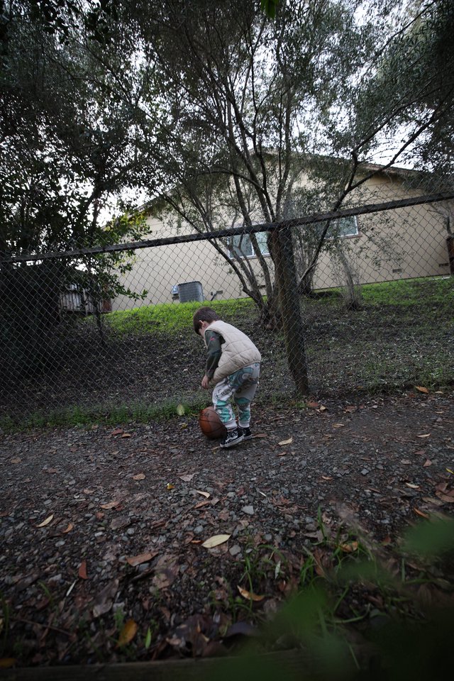 Child Playing Basketball in Suburban Backyard