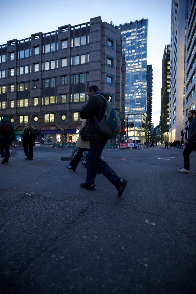 Urban Commuter Crossing City Square at Dusk