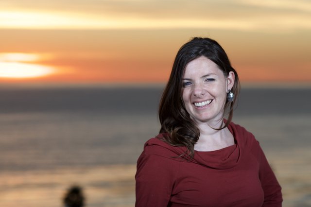 Smiling Woman at Golden Hour Seaside Sunset