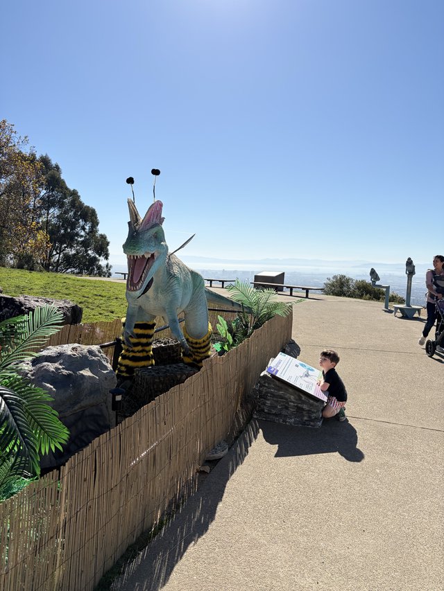 Whimsical Bee-Dinosaur Sculpture at Coastal Viewpoint