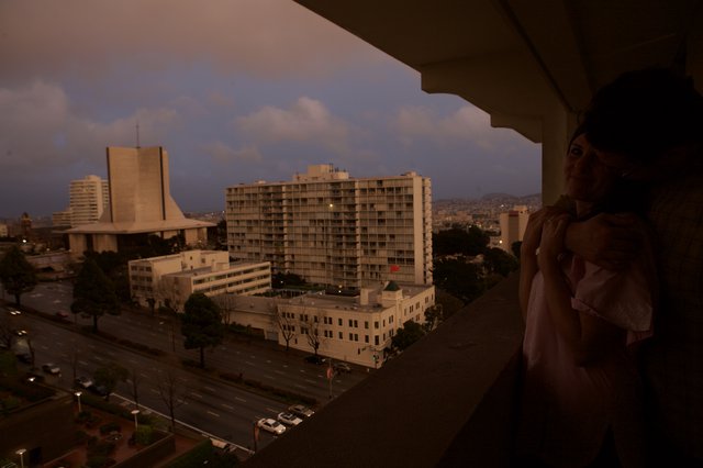 Woman on Hotel Balcony Overlooking San Francisco at Dusk
