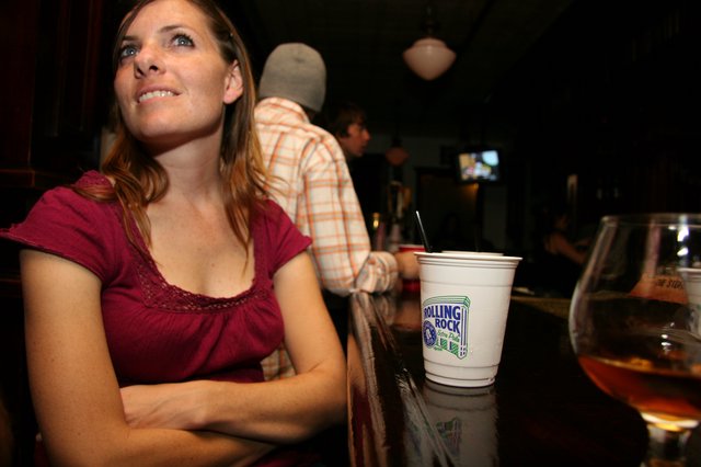Woman at a Bar Watching Something Intently