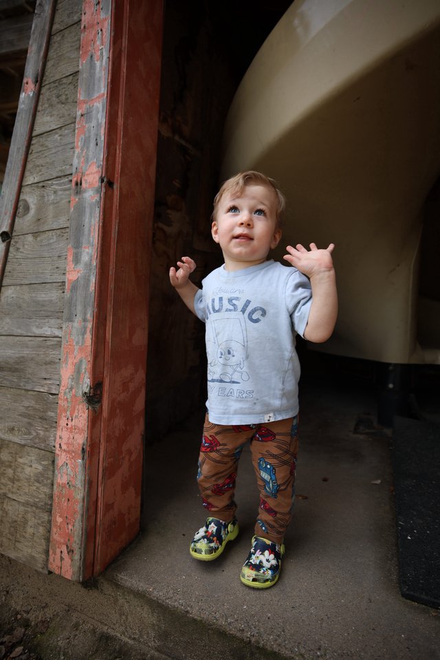 Young Child's Wonder in Rustic Doorway