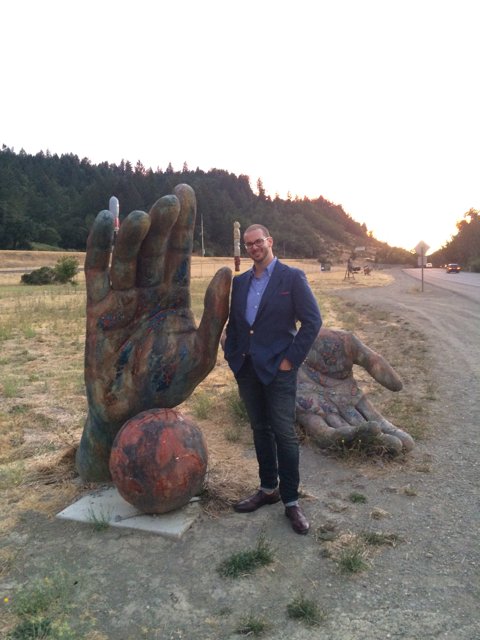 The Formal Man and the Giant Hand Sculpture