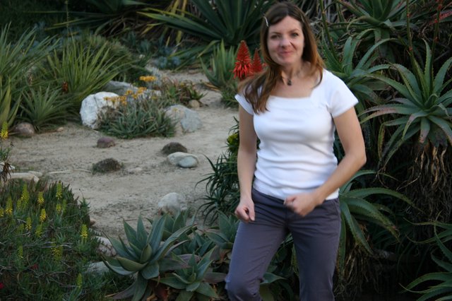 Woman Smiling Among Desert Succulents and Cacti