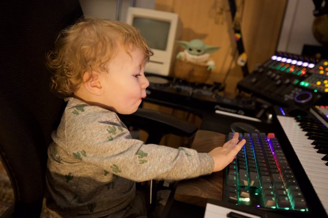 Young Child Exploring Music Production Equipment at Home