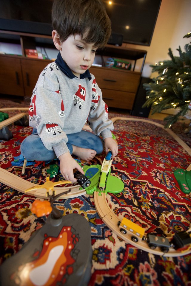 Young Boy Playing with Wooden Train Set on Christmas