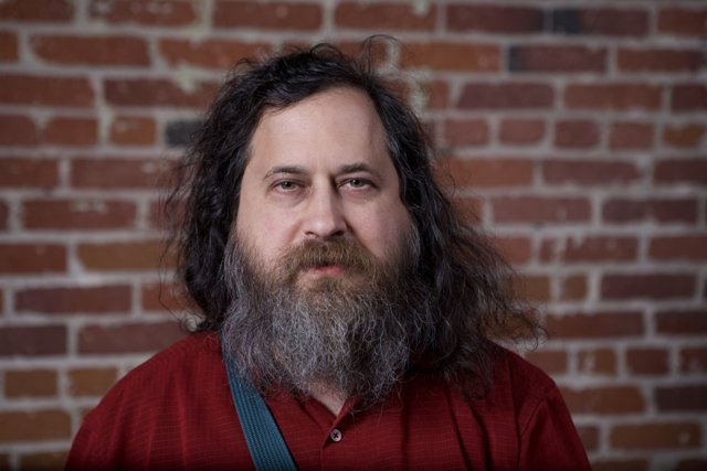 Richard Stallman Poses in Front of Brick Wall