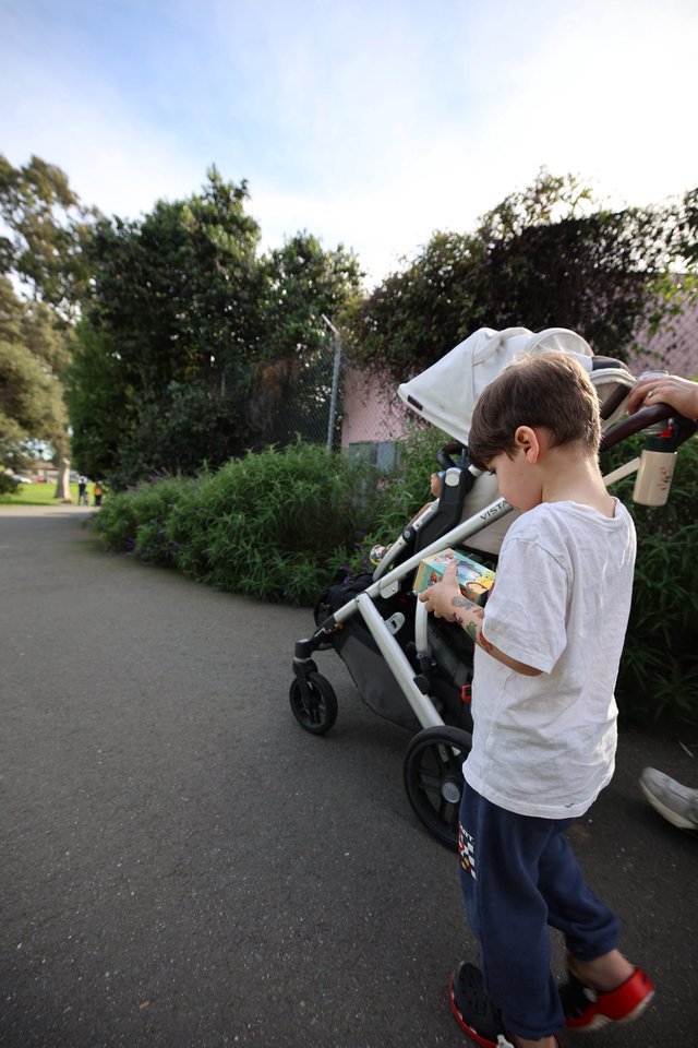 Young Boy with Snack by Stroller in Residential Area