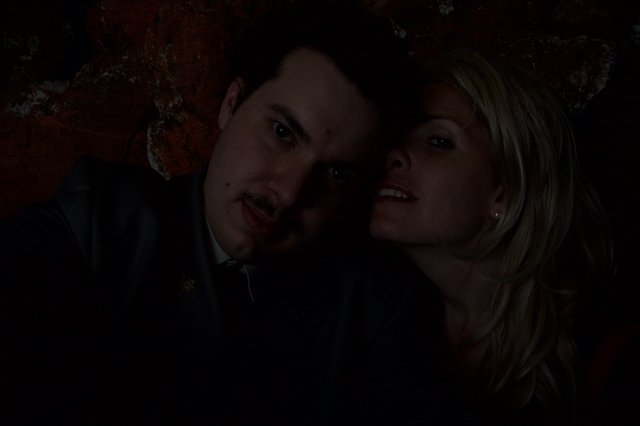 Dark Halloween Portrait of Couple Against Rustic Wall