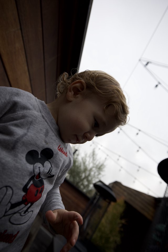 Young Child in Mickey Mouse Sweatshirt Looking Down