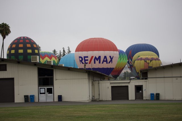 RE/MAX Hot Air Balloons Rise Over Fairgrounds Buildings