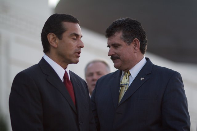 Two Men in Suits Stand Beside Antonio Villaraigosa