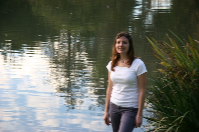 Young Woman Smiling by a Reflective Pond