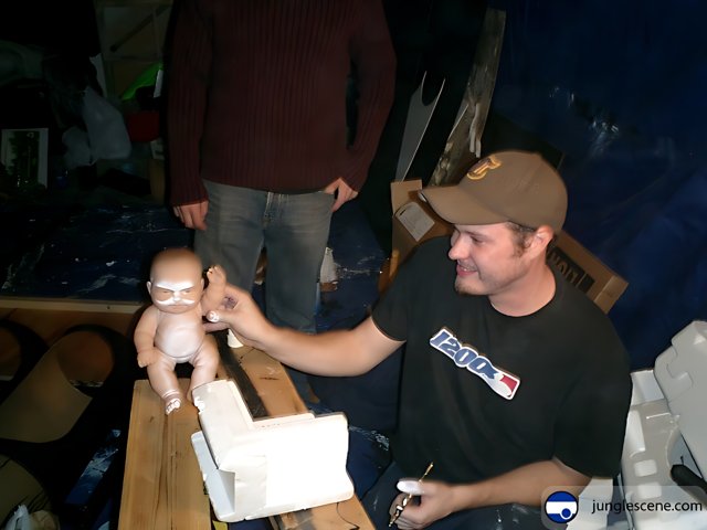 Man and Doll in front of Wooden Table