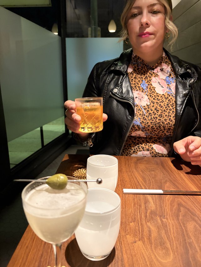 Woman Enjoying Cocktails at Modern Restaurant Table