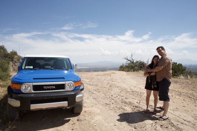 Couple Embracing Beside Blue Toyota FJ Cruiser Overlook