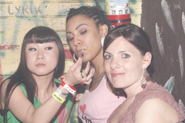 Three Women Posing at a Nightclub Graffiti Wall
