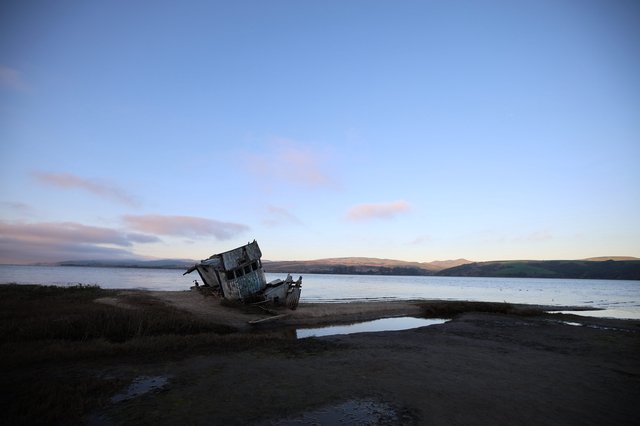 Abandoned Shipwreck at Twilight on Coastal Shore