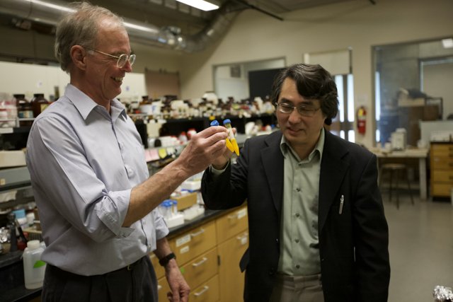 Two Scientists Examining a Yellow Object in a Laboratory