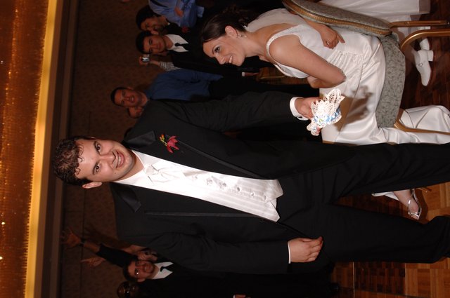Groom Displays Wedding Garter at Reception Celebration
