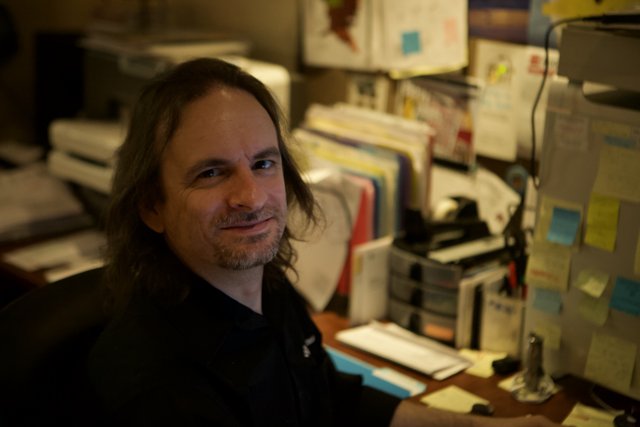 Long-Haired Man at his Workstation