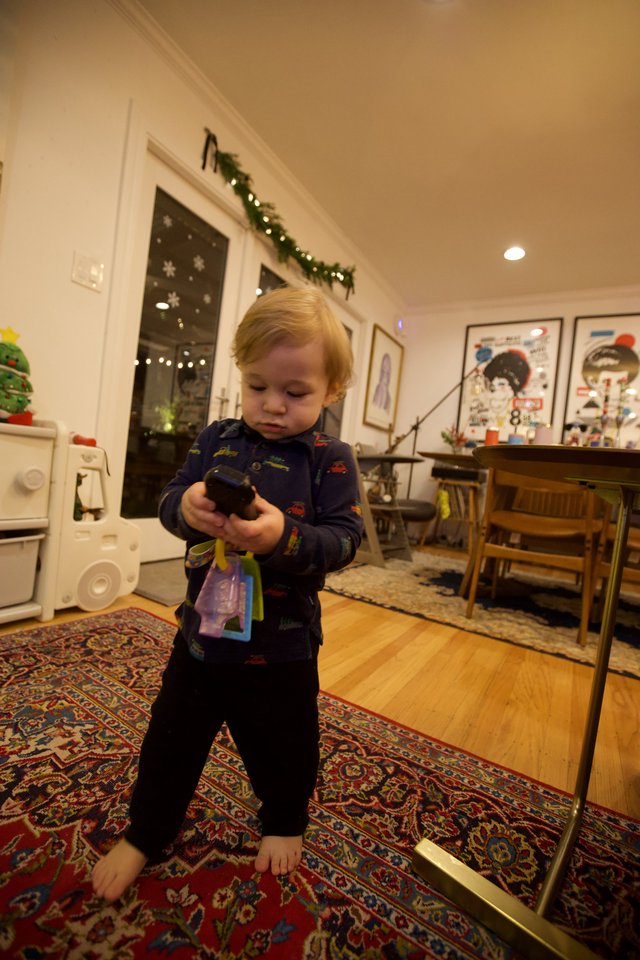 Toddler Examining Toy in Cozy Christmas Home