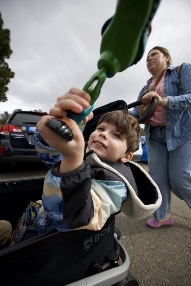 Young Boy with Dinosaur Toy at Parking Lot Gathering