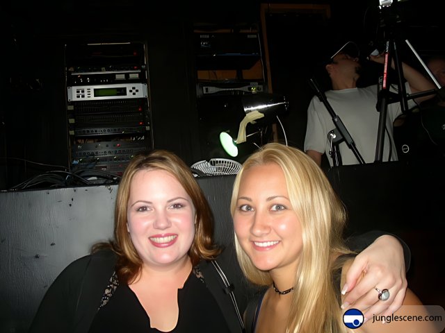 Snapshot of Two Women Posing in front of a Microphone