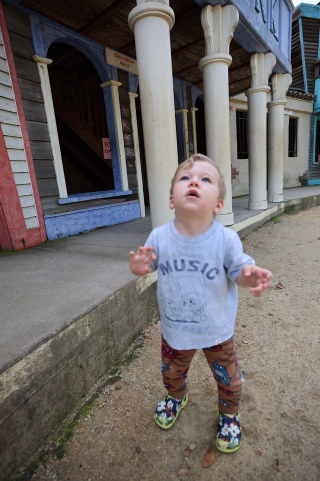 Young Child Looking Up in Wonder at Vintage Storefront