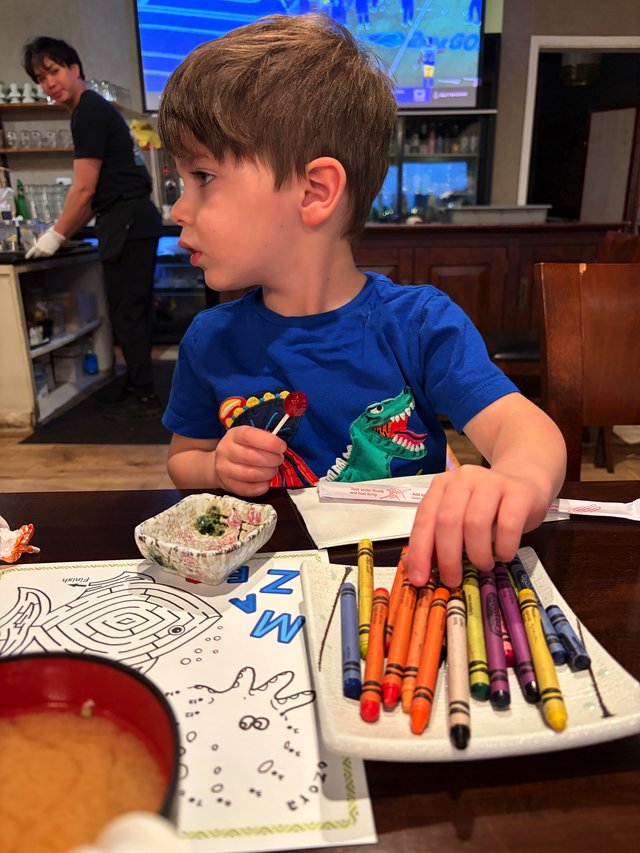 Young Boy Coloring with Crayons at Home