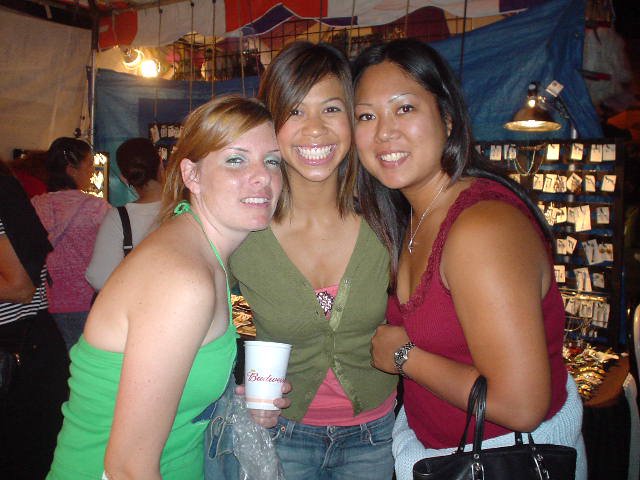 Three Friends Smiling Together at Outdoor Festival