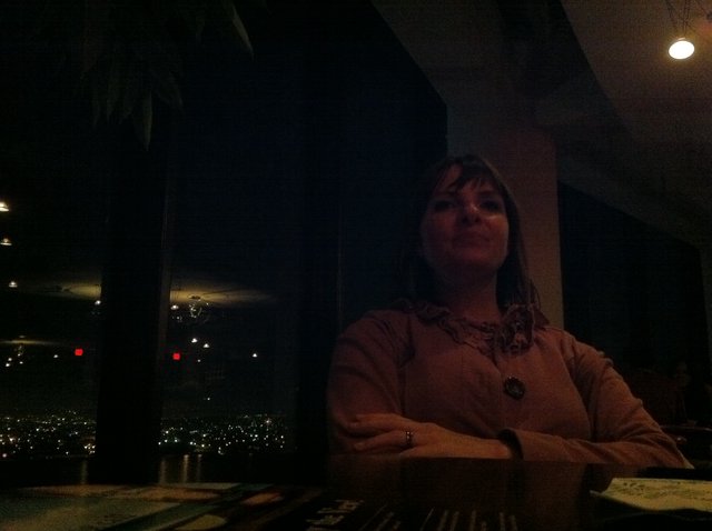 Contemplative Woman at Dimly Lit Urban Restaurant