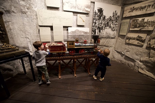 Children Exploring Historic Train Exhibit in Museum