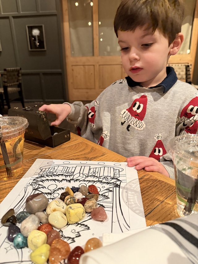 Young Boy Discovers Gemstone Treasure at Restaurant Table