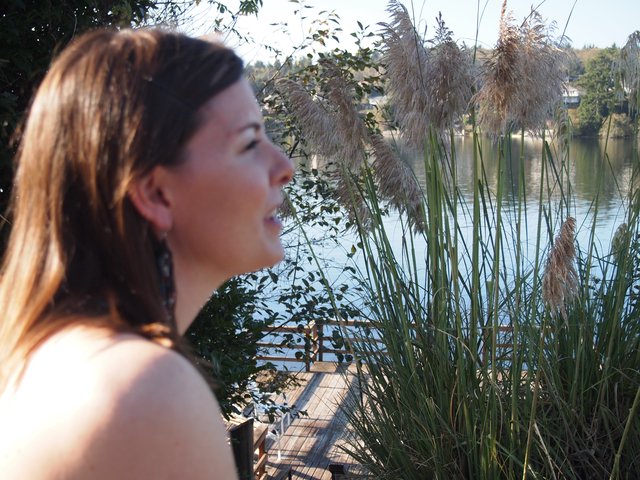 Contemplative Woman by Lakeside Dock at Golden Hour
