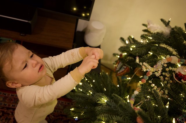 Toddler Decorating Christmas Tree with Ornaments