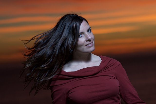 Wind-Swept Beauty Glowing Against Fiery Sunset Sky