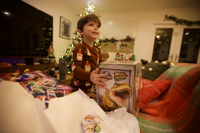 Christmas Morning Joy: Boy Opening Dinosaur Gift