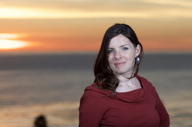 Woman Smiling at Sunset by the Sea