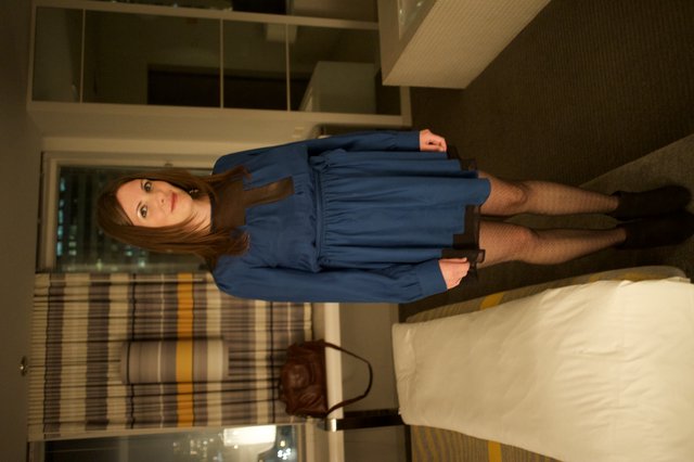 Woman in Blue Dress Poses in Modern Hotel Room