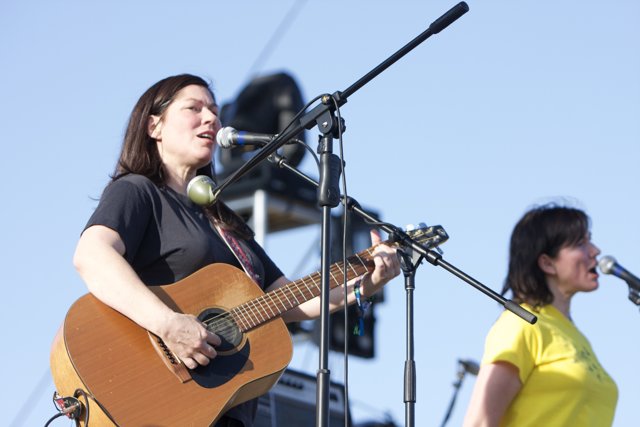 Kim Deal strums her guitar under the bright blue sky at Coachella