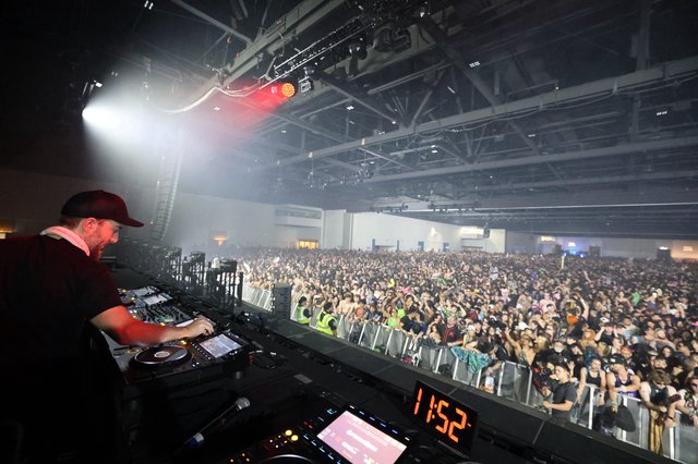 DJ Performs for Massive Indoor Festival Crowd at Midnight