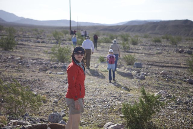 Desert Hiker Pauses on Rocky Trail Amid Group