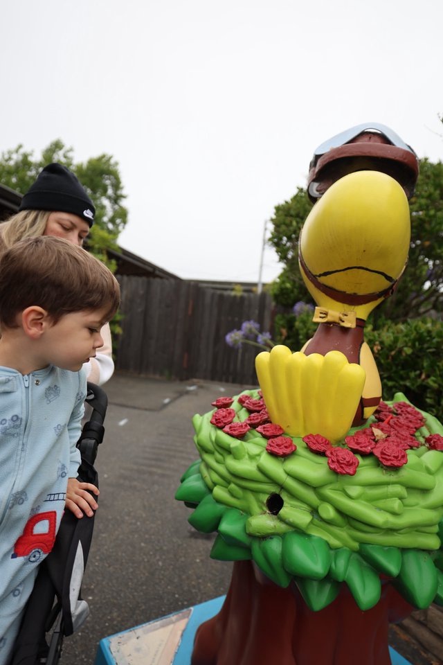 Child's Wonder at Colorful Duck Mascot Statue